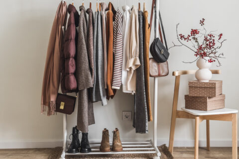 Women's seasonal autumn clothes on the floor hanger in the dressing room