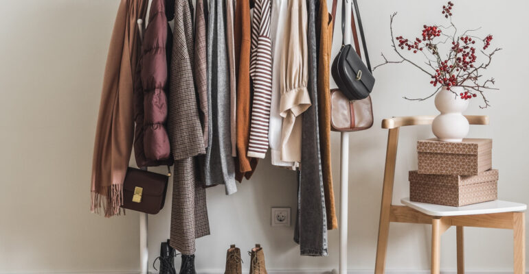 Women's seasonal autumn clothes on the floor hanger in the dressing room